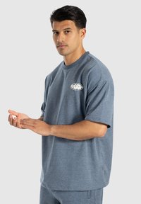 Grå kortærmet t-shirt lavet af blødt stof, med rund halsudskæring og et lille hvidt logo på venstre side. Casual pasform, glat tekstur.