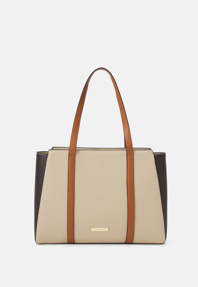 Shoppingtaske med en beige midte, mørkebrune sider og tan læderstropper. Har en glat tekstur og en lille guldbelagt logoaccent på forsiden.