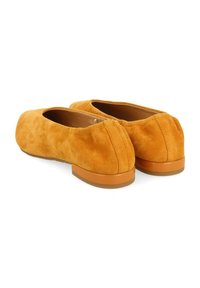 Ballerines en suède orange avec un bout arrondi, un petit talon en caoutchouc et des détails cousus à l'arrière. Texture douce et design minimaliste.