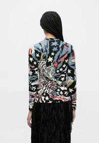 Έγχρωμο πουκάμισο με μακριά μανίκια, με εκτύπωση τίγρης, αστέρια και αφηρημένα μοτίβα· διαθέτει ελαστικό ύφασμα και εφαρμοστό σχέδιο.