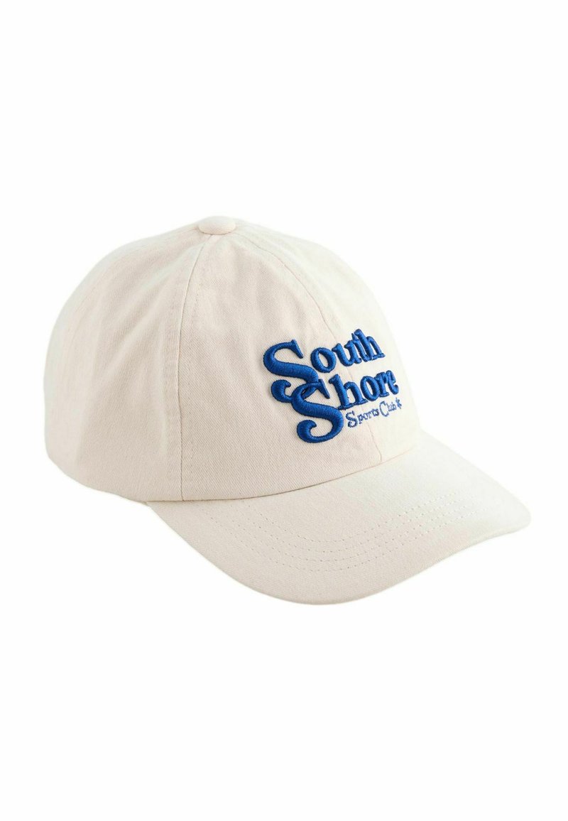 Casquette de baseball en coton beige avec le texte brodé en bleu "South Shore Sports Club" à l'avant. Visière courbée et bouton en tissu sur le dessus.