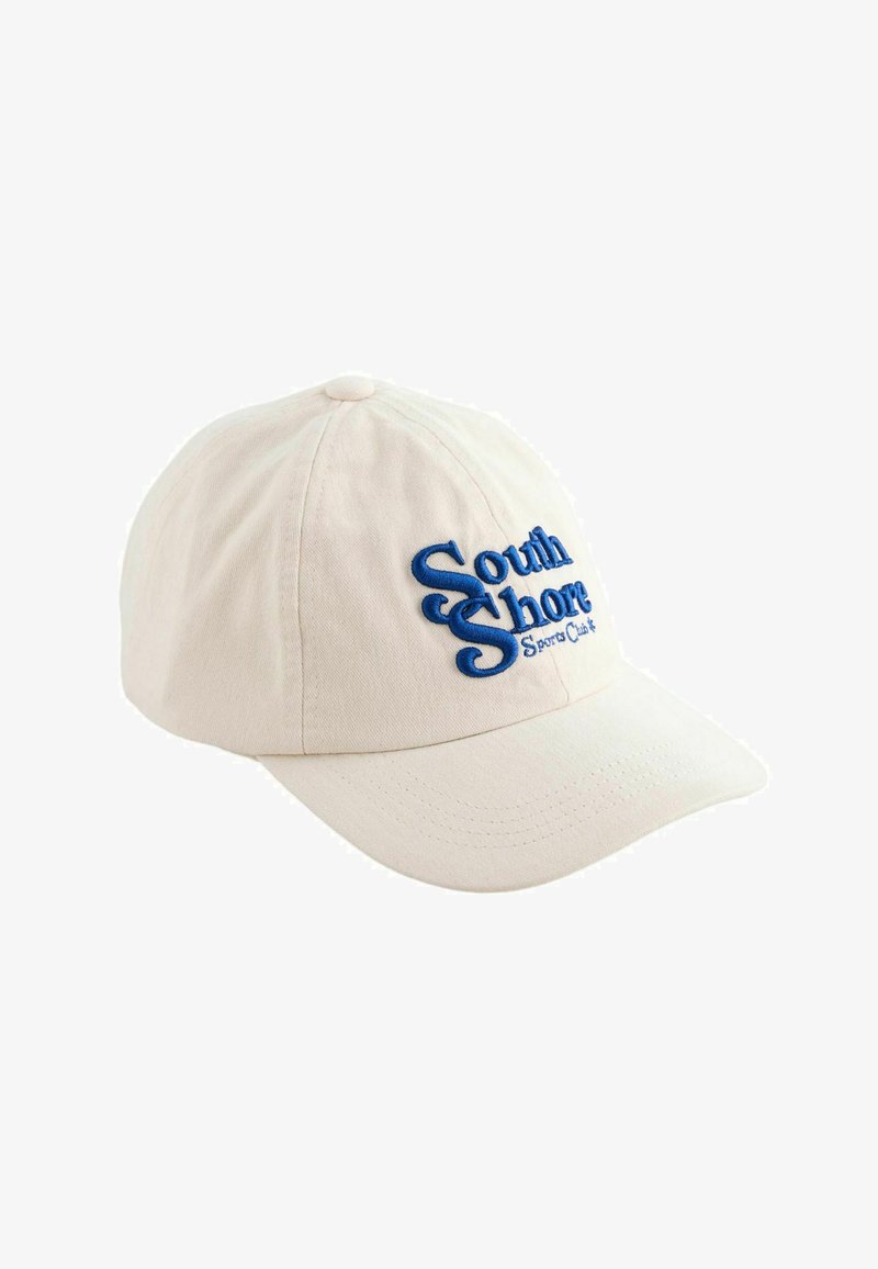 Cappellino da baseball in cotone beige con il testo ricamato blu "South Shore Sports Club" sul davanti. Visiera curva e bottoncino in tessuto sulla parte superiore.