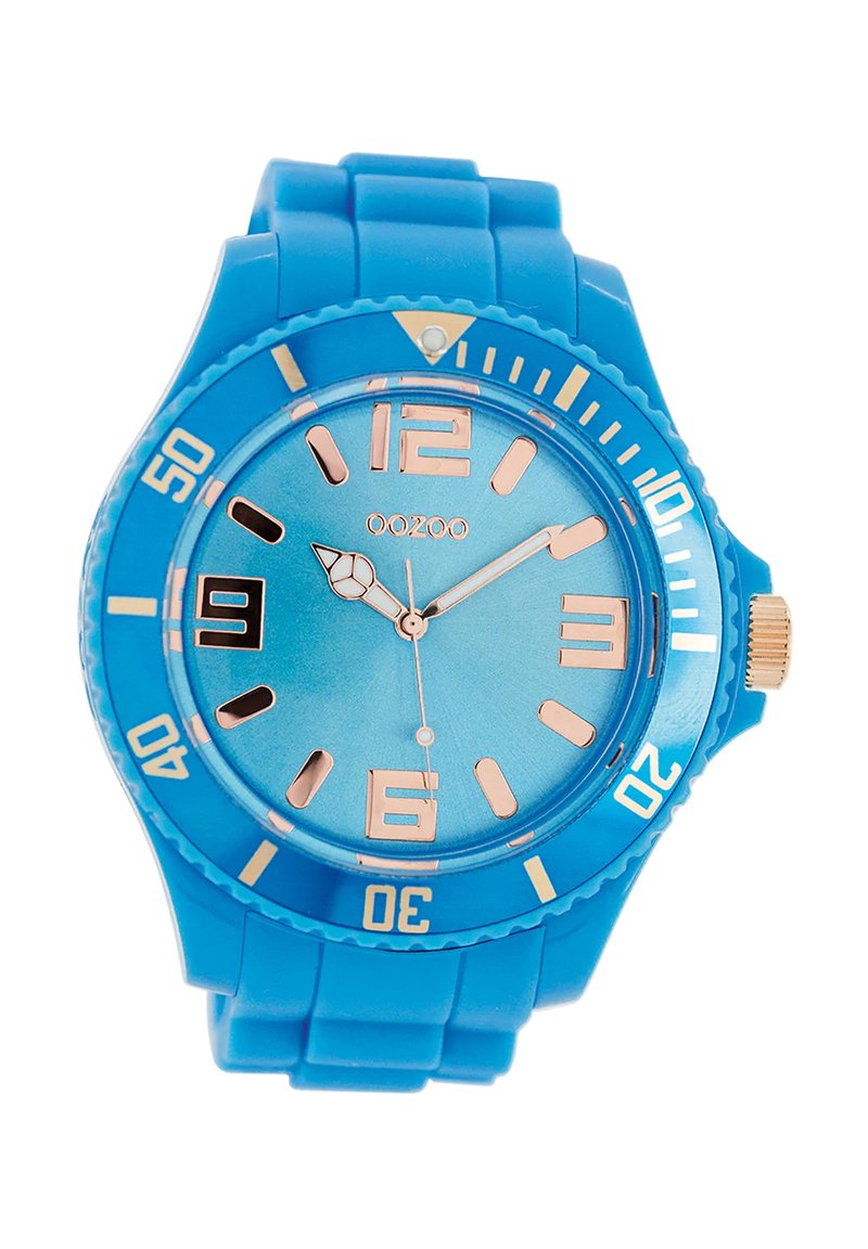Montre en silicone bleue avec un cadran rond, un cadran bleu clair, des index en or rose et une couronne dorée, présentant une lunette texturée et des incréments numérotés.