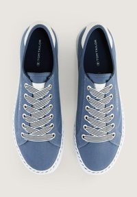 Blaue Leinenschuhe mit weißen Akzenten, featuring eine runde Zehenpartie, Schnürdesign und kontrastierende gestreifte Schnürsenkel für zusätzliche Details.