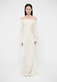 Dlhé biele šaty s odhalenými ramenami a diagonálnymi kvetinovými vzormi, priliehavé rukávy a hladká textúra, splývajúce až po zem.