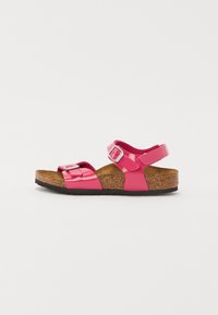 Rosa lackläder sandaler med två justerbara remmar, en korkfotbädd och en texturerad gummisula. Har en metallisk spänne accent.