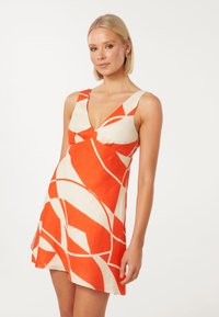 Kurzes Kleid in Creme und Orange mit V-Ausschnitt, das auffällige abstrakte Muster und eine taillierte Passform aufweist, aus leichtem Stoff gefertigt.