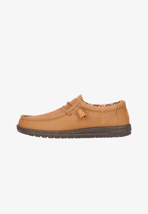 Scarpe slip-on in tela beige con punta tondeggiante, dettaglio in pizzo e soletta decorata. La suola in gomma presenta un design maculato per una migliore aderenza.