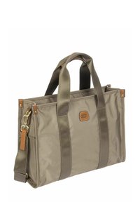 Sac fourre-tout rectangulaire beige avec deux poignées solides, une bandoulière détachable et une petite étiquette en cuir de la marque à l'avant.