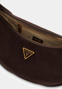 Borsa a spalla in suede marrone con hardware dorato, dotata di una targhetta logo triangolare. Interno dettagliato con chiusura a zip.