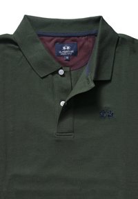 Tmavě zelené polo tričko z texturované látky. Má dvouknoflíkový límec, námořnicky modrý lem límce a vyšívané logo na hrudi.