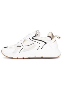 Zapatilla blanca con paneles de malla, acentos negros y detalles metálicos dorados. Presenta una punta redondeada, un diseño de cordones y una suela acolchada.