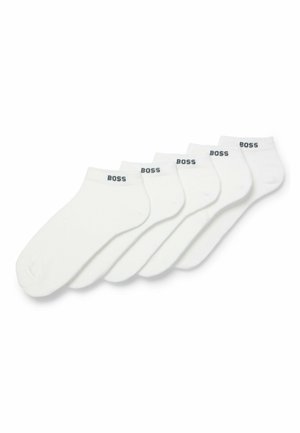 Cinq paires de chaussettes blanches de cheville en mélange de coton, avec un design uni arborant un logo noir "BOSS" sur les bords.