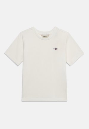 Fehér rövid ujjú, kerek nyakú póló apró hímzett logóval a bal mellrészen, egyszínű háttéren bemutatva.