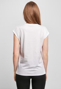 White short-sleeve t-shirt with rolled cuffs, made of a soft, lightweight fabric. Smooth texture and relaxed fit with a round neckline.