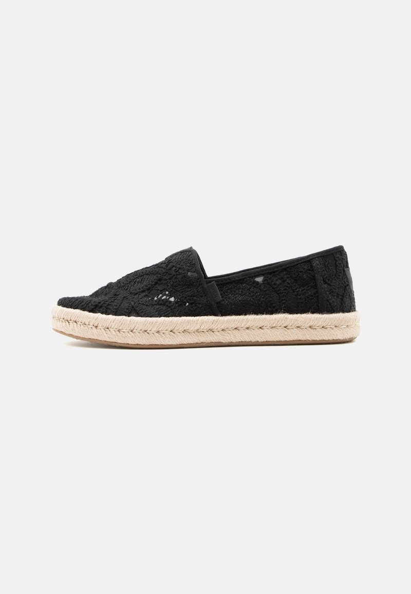 Espadrille en dentelle noire avec semelle tissée beige, vue de profil sur un fond gris clair uni.
