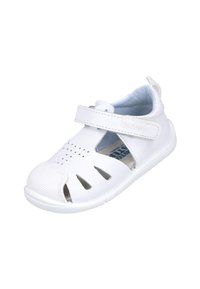 Sandalia blanca hecha de material sintético, con puntera cerrada, lados con aberturas, correa ajustable de velcro y suela texturizada.