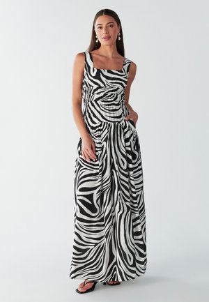 Abito maxi a righe zebrate in bianco e nero con scollo quadrato, vita arricciata e tasche laterali. Tessuto leggero con un design fluido.
