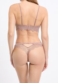 Lace-back beha en string set in zacht mauve, met een fijne bloemrijke kanten rand en verstelbare bandjes voor een perfecte pasvorm.