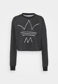 Kort svart tröja med långa ärmar, pryds av en vit linjegrafik av en krona och abstrakta former på framsidan. Mjuk textur.