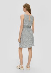 Blumenmusterkleid mit tailliertem Schnitt, ärmellosem Design und Schlüsselloch-Detail im Rücken. Aus leichtem Stoff gefertigt, mit einem schwingenden Rock.