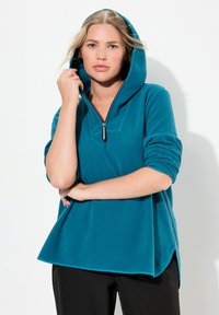Felpa con cappuccio in pile teal, con mezza zip sul davanti, maniche lunghe e vestibilità rilassata, caratterizzata da aperture laterali e polsini a coste.