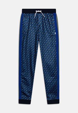 Pantaloni sportivi blu navy con stampa geometrica, vita elasticizzata, tasche frontali e strisce laterali blu-verdi. Realizzati in materiale leggero e liscio.