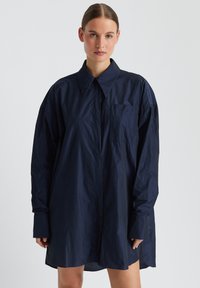 Lässiges oversize Hemd in marineblau aus leichtem Material, mit klassischem Kragen, langen Ärmeln, einer Brusttasche und glatter Oberfläche.