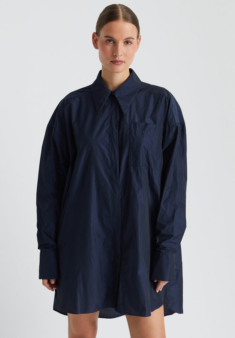 Lässiges oversize Hemd in marineblau aus leichtem Material, mit klassischem Kragen, langen Ärmeln, einer Brusttasche und glatter Oberfläche.