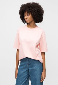 Φούξια oversized μπλούζα από βαμβάκι, με στρογγυλή λαιμόκοψη και κοντά μανίκια, με μικρό λευκό λογότυπο στο στήθος.