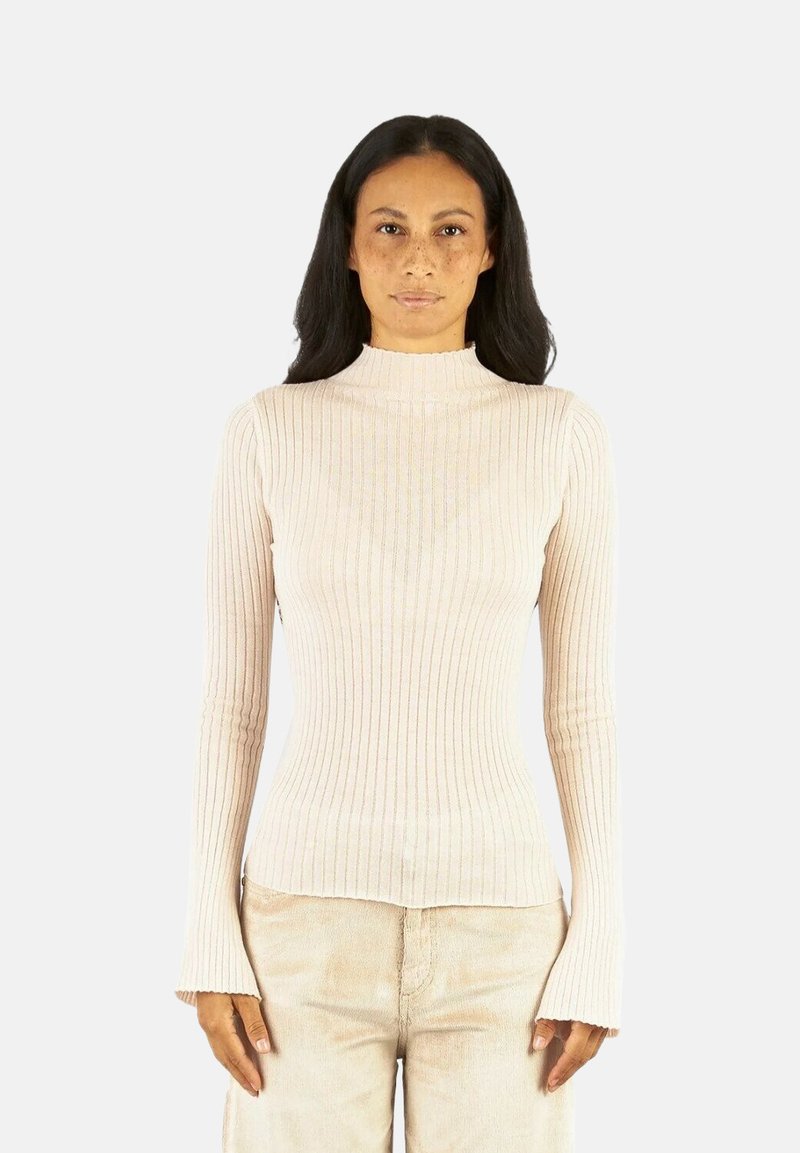 Maglione beige a collo alto a coste con maniche lunghe e svasate. Materiale morbido e elastico; la silhouette aderente esalta la forma del corpo.