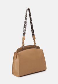 Sac à main structuré couleur fauve avec deux bandoulières imprimé léopard et des éléments métalliques argentés, présenté sur un fond clair uni.
