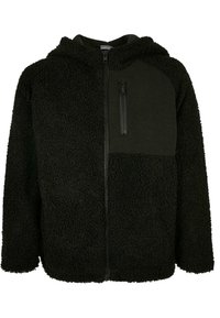 Schwarze Fleece-Zip-Up-Hoodie mit strukturiertem Außenmaterial, glattem schwarzen Einsatz auf der Brust und einer Reißverschlusstasche auf der Vorderseite.
