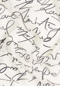 Leichter Stoffschal mit cremefarbigem Hintergrund und fließendem, schwarzem Handschrift-Muster, das ein texturiertes, mehrschichtiges Erscheinungsbild erzeugt.