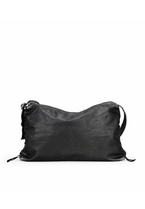 Bolso de cuero negro con una textura suave, forma blanda y correa ajustable. Presenta lados fruncidos y un cierre de cordón en la parte inferior.