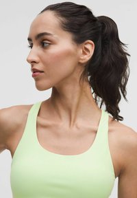Világoszöld sportos top kerek nyakkivágással és széles pántokkal, sima textúrával és testhezálló fazonnal.