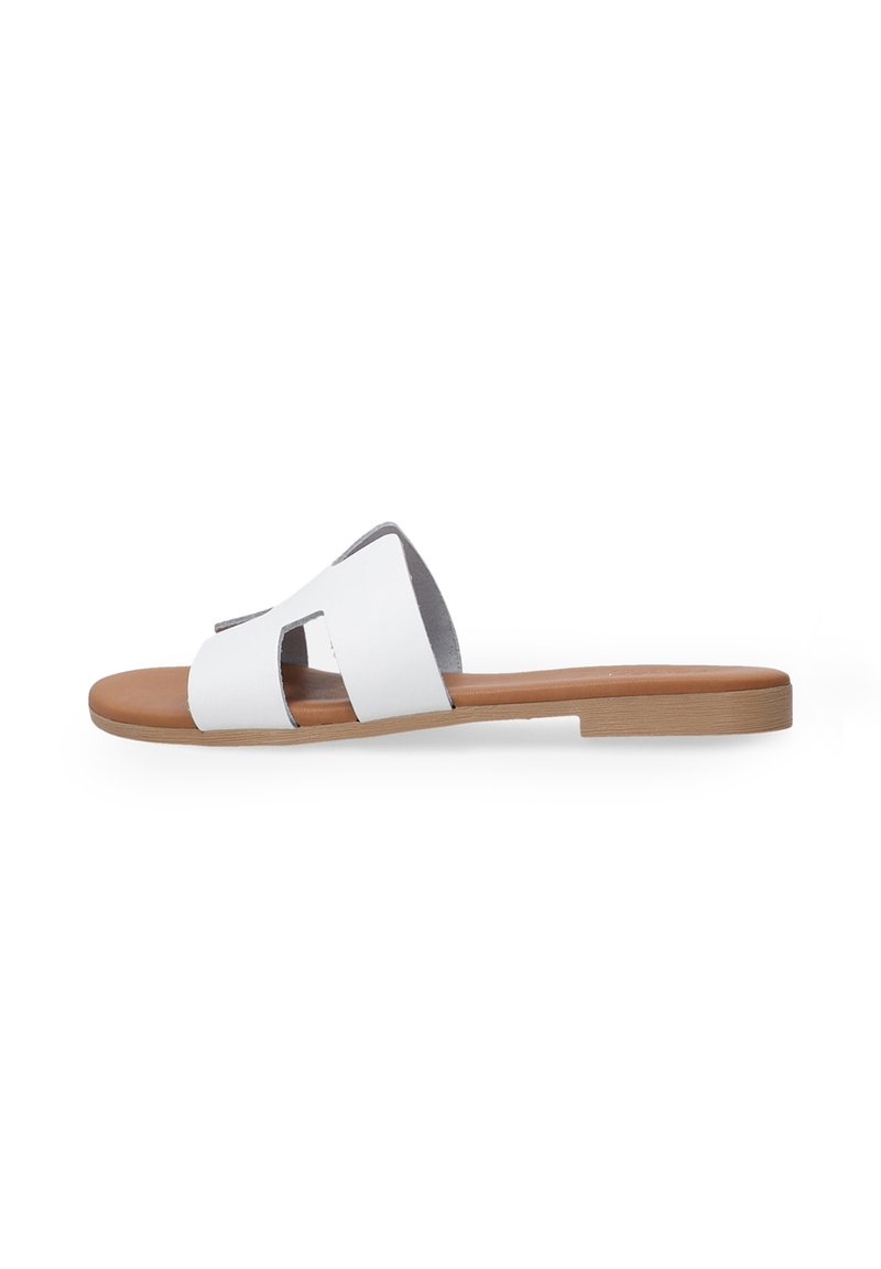 Sandale à glissière en cuir blanc avec un design découpé ; semelle synthétique tan légèrement rembourrée ; bout ouvert, plate et style minimaliste.