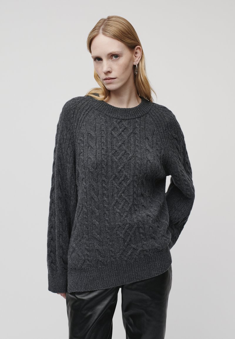 Dunkelgrauer Kabelstrickpullover mit Rundhalsausschnitt und langen Ärmeln, der strukturierte Muster und eine lockere Passform aufweist.