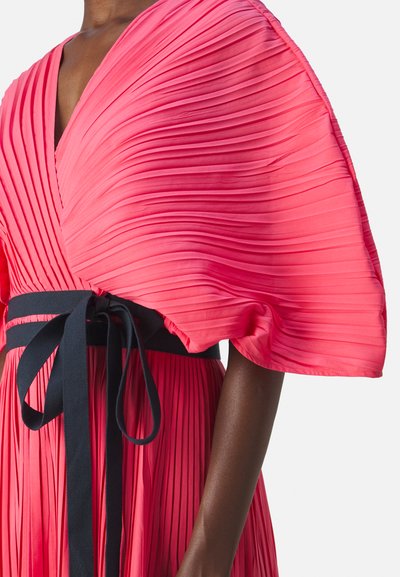 Pucci-kleid i skarp pink med dyb V-hals og brede, draperede ærmer. Udstyret med et mørkt bælte, der er bundet i en sløjfe for ekstra detaljer.