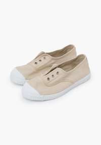 Scarpe slip-on in tela beige con punta in gomma bianca, cinque occhielli argentati e suola in gomma bianca texturizzata.