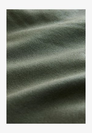 Olijfgroene stof met een fijne textuur, die lichte golven en glans vertoont, wat duidt op zachtheid en rekbaarheid.