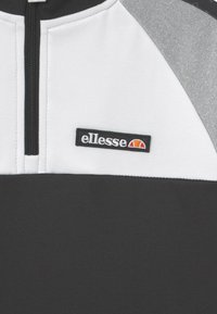 Maglia zip-up in bianco e nero con accenti grigi. Presenta una texture liscia e un logo "ellesse" ricamato sul petto.