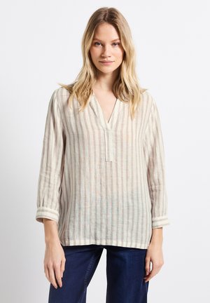 Linned skjorta med randigt mönster i beige och ljusbrun, med V-ringning, långa ärmar och uppvikta ärmslut. Har en avslappnad passform och en naturlig textur.