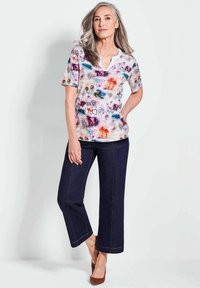 Korte mouwen, kleurrijke bloemen top met heldere prints, gecombineerd met donker denim wijde pijpen broek. Zachte stof en een ontspannen pasvorm ontwerp.