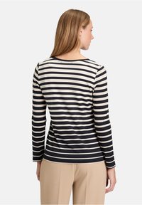 Gestreiftes Langarmoberteil mit abwechselndem Navy- und Creme-Streifen, Rundhalsausschnitt und taillierter Silhouette mit glatter Textur.