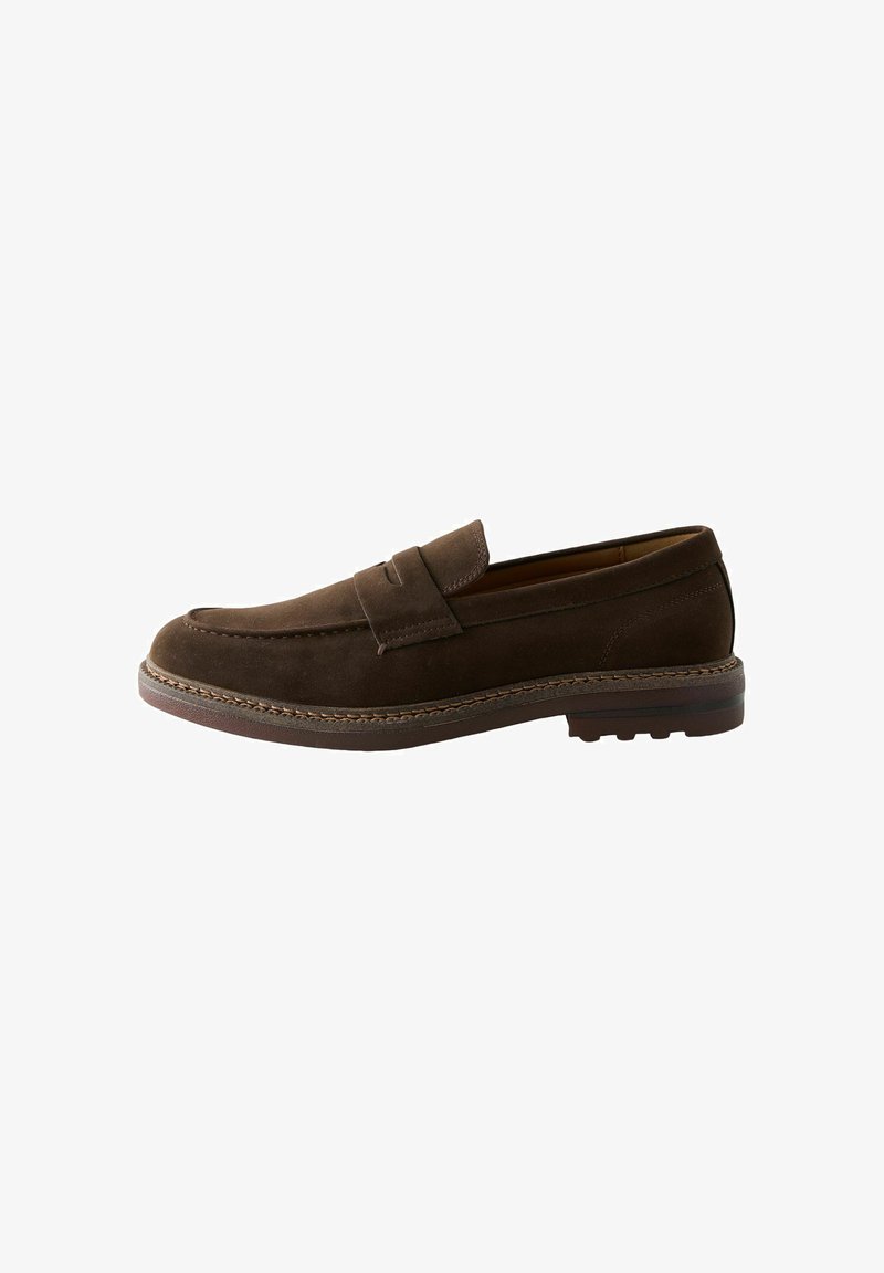 Mocassin en daim marron avec un bout arrondi, des coutures décoratives et une semelle en caoutchouc basse. Design simple sans éléments métalliques ni accents visibles.