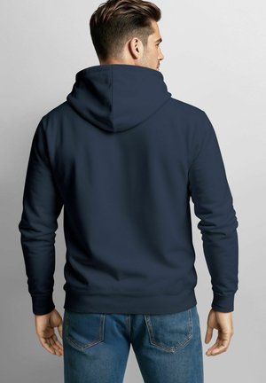 Navy blue hoodie with a drawstring hood, soft fabric texture, and ribbed cuffs, paired with light blue denim jeans.