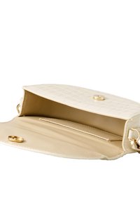 Borsa a mano color crema con un motivo a trama. L'interno è beige e presenta una tasca con fessura. Finiture in metallo dorato e chiusura a scatto.