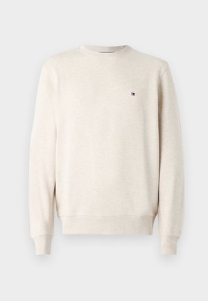 Sudadera de color beige claro hecha de tela suave, con cuello redondo, puños acanalados y un pequeño logo en el pecho. Diseño sencillo y casual.