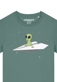 Grünes Baumwoll-T-Shirt mit einem Cartoon-Aliens auf einem weißen Papierflieger, vor einem Hintergrund aus kleinen weißen Sternen.